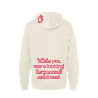 Beige hoodie with pink text on the back and a small logo on the hood.